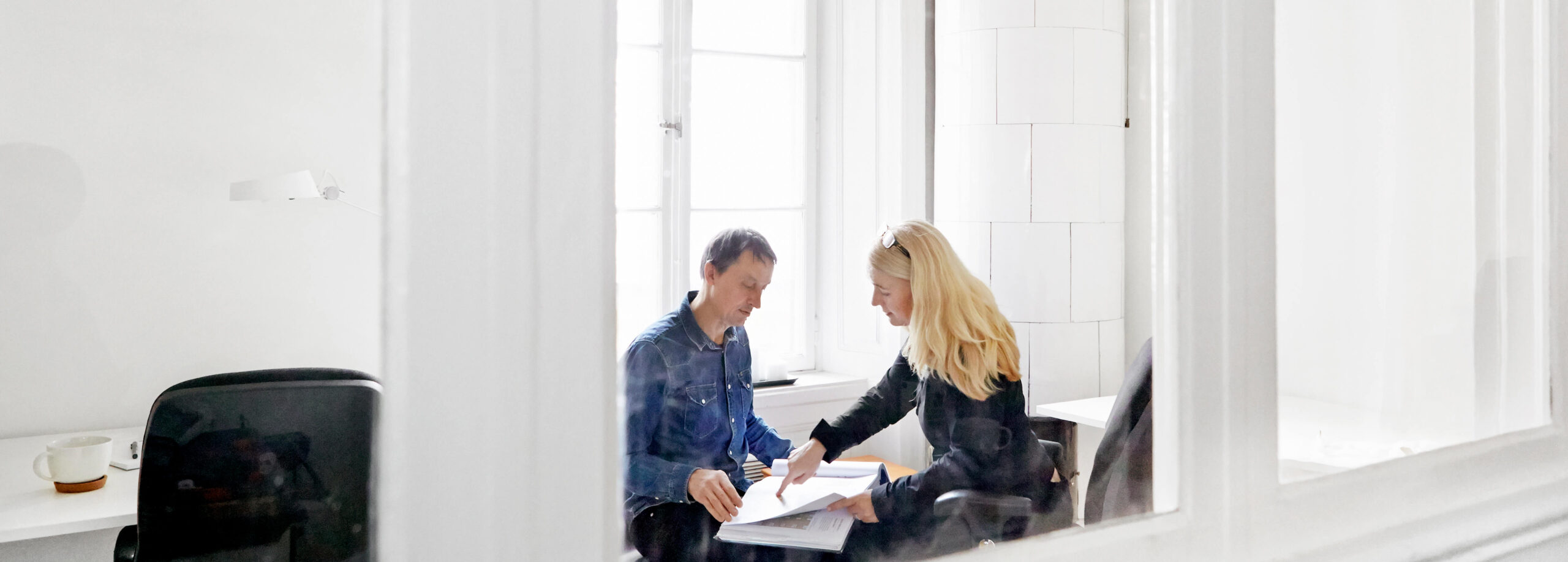 Bengt och Mia som sitter och tittar ner på ett projektarbete i ett ljust rum
